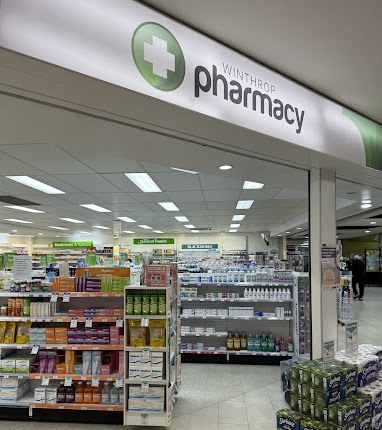 Entrance to Winthrop Pharmacy inside Winthrop Village Shopping Centre, with the pharmacy sign above and shelves inside